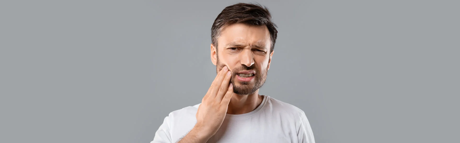 Man with severe tooth pain and in the need of emergency dentistry in Ajax, ON.