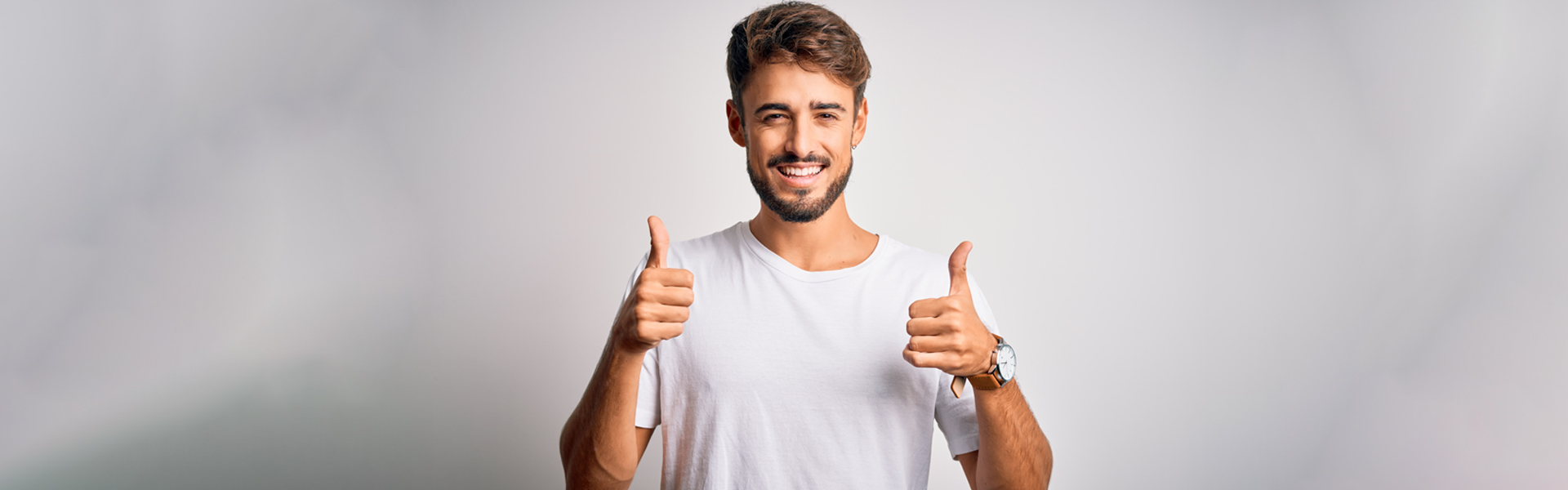 Smiling boy showing thumbs up.