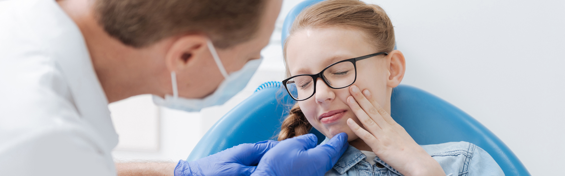 Kids dentist examining a girl for dental pain and in Ajax, ON.